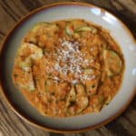 zucchini trapanese. A simple dish of sauteed shaved zucchini in a tomato, almond, basil and calabrian chile pesto topped with grated almond.